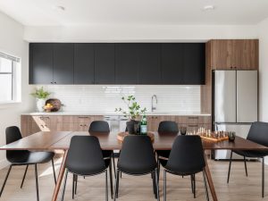 Resident amenity kitchen and dining area at Link on Long Lake in Nanaimo, with large communal table and modern cabinetry.
