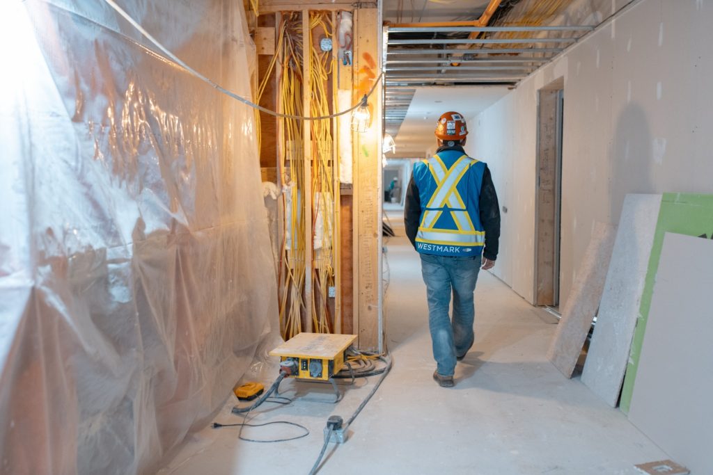 Westmark construction worker walking through the interior of a multi-family building under construction on Vancouver Island.